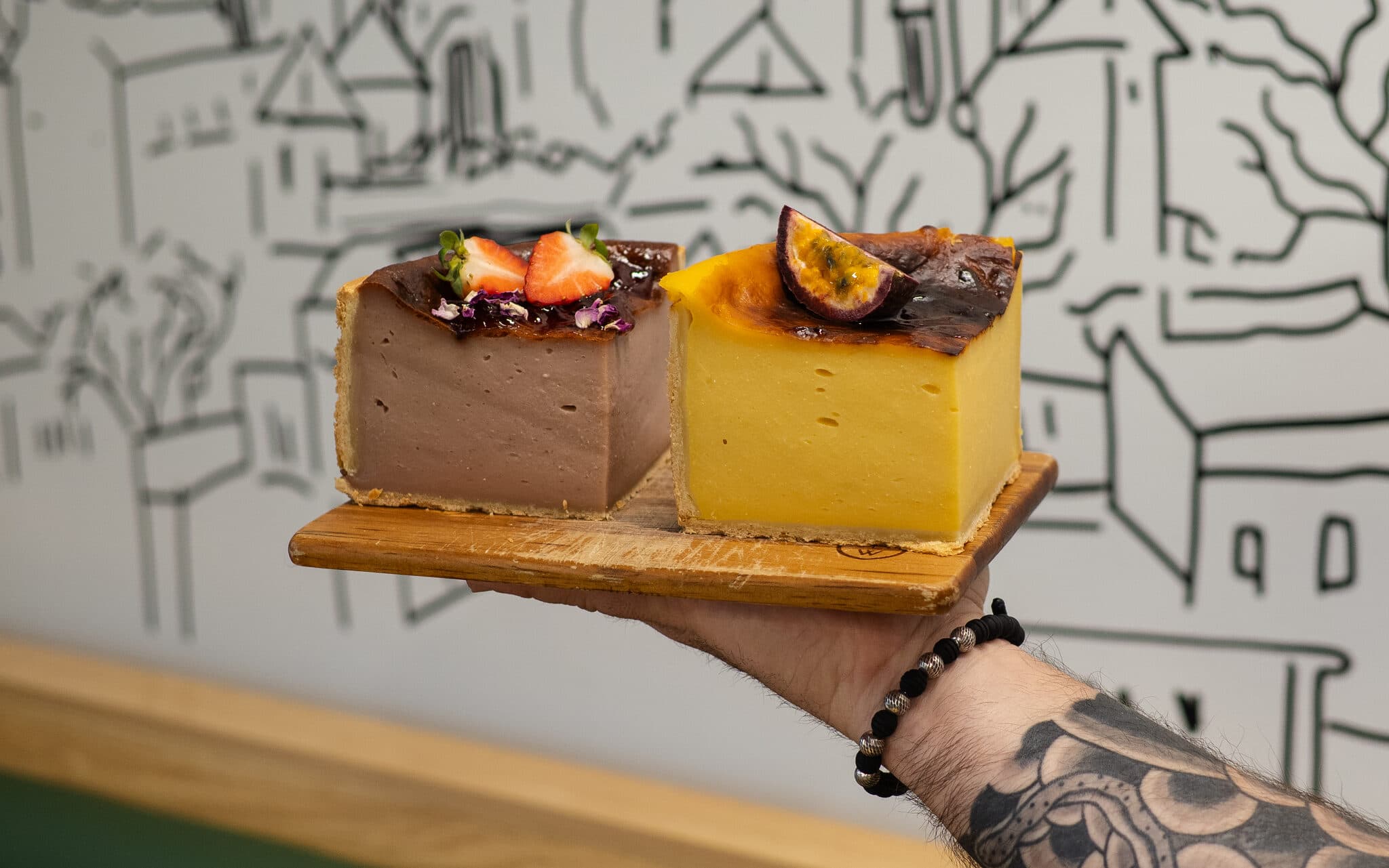 Two decorated cake slices against the Anaïs illustrated wall