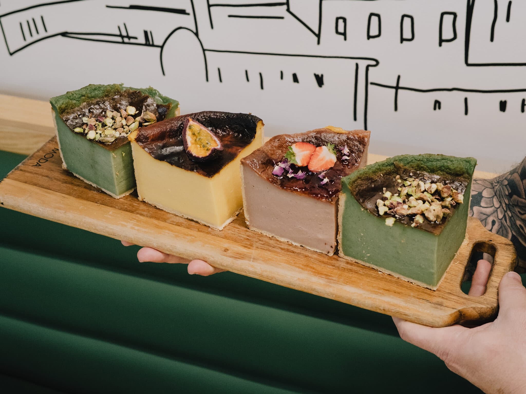 Four decorated dessert squares on a serving board