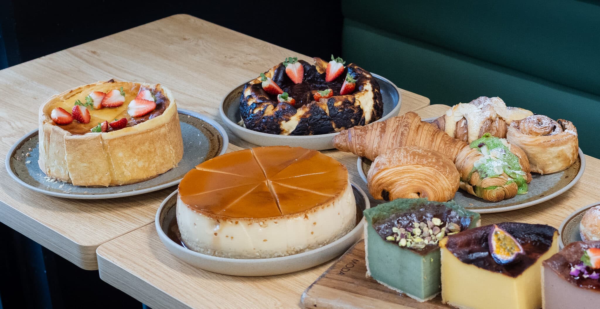 A table filled with pastries, tarts, flan and dessert squares